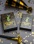 Two 'Froggy Party' game boxes with gold and black party hats and confetti on a gray background.