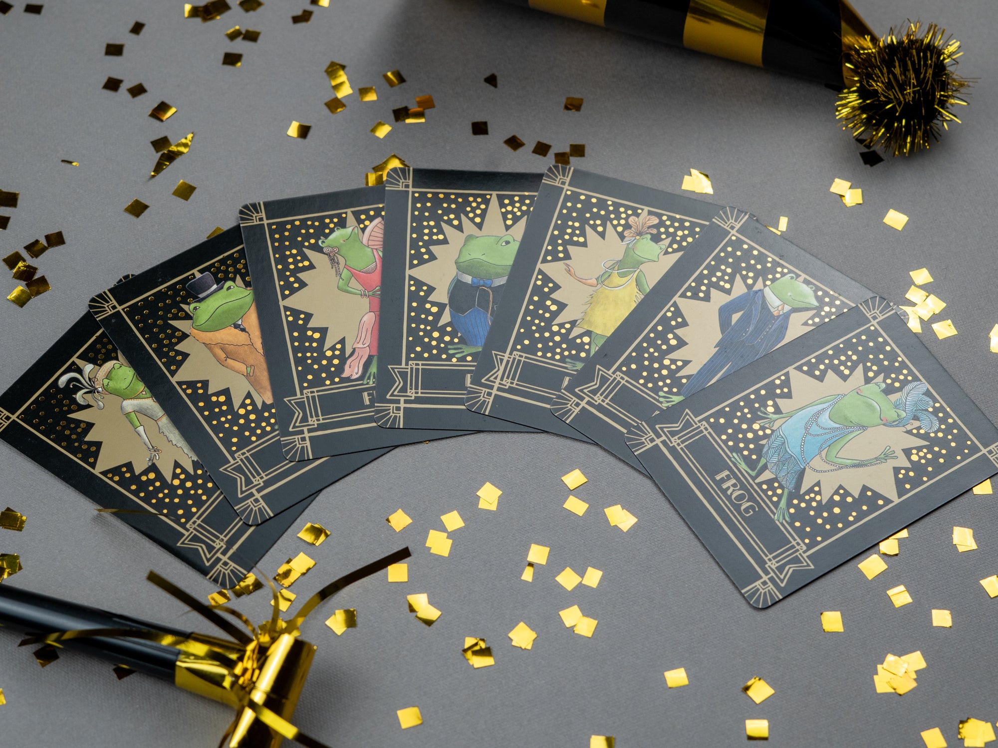 Set of seven sparkly Frog cards with decorative gold confetti on a gray background