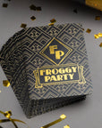 Stack of 'Froggy Party' cards with gold confetti on a gray background