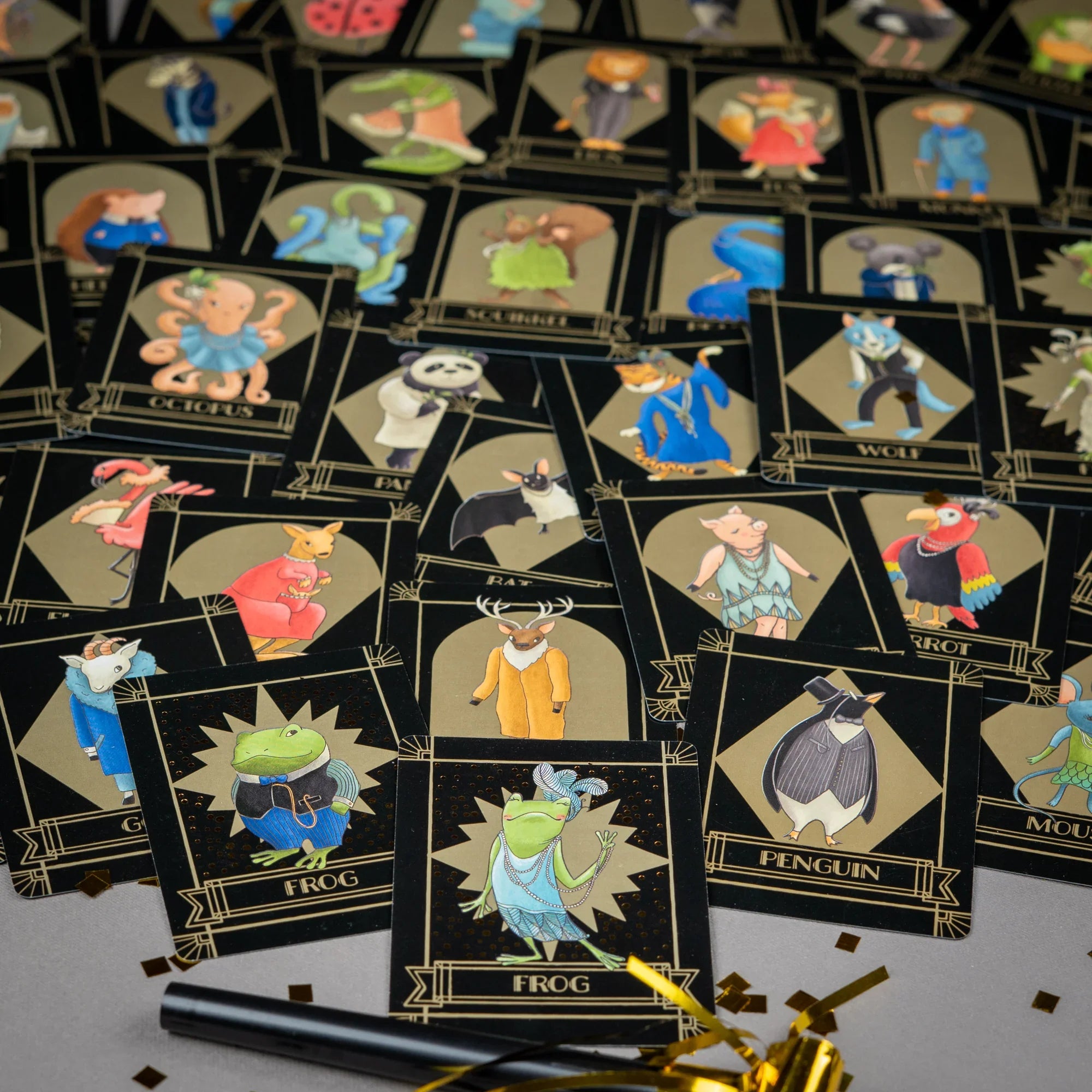 Collection of Froggy Party animal cards on a gray surface with confetti.